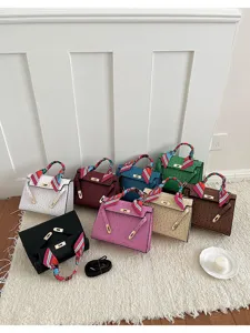 Vista detallada de bolsos Kelly de avestruz multicolor con pañuelo decorativo en el asa.