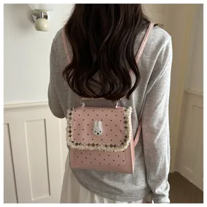 Pink polka dot backpack detail showing cute rabbit applique and lace trim on back.