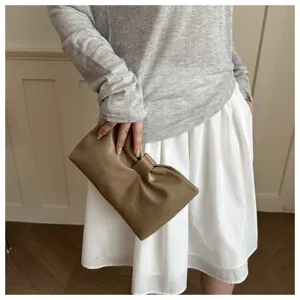 Brown bow knot clutch bag detail shot showcasing soft leather texture and stylish daily look.