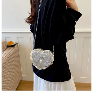 Joli sac à bandoulière en forme de cœur pour femme avec dentelle nœud et chaîne perlée.