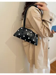 Close-up detail of the chic polka dot bowling bag, featuring sleek texture and style.