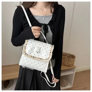 Details of the white polka dot mini backpack featuring a cute rabbit patch and fringe trim.