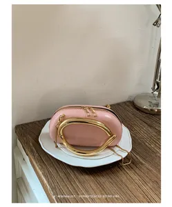 Fashion pink shoulder round bag with metal handle, chic niche design for women daily use.
