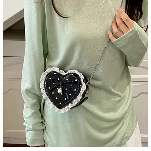 Joli sac bandoulière en forme de cœur avec volants en dentelle, pois et pendentif perle détail.