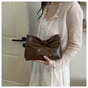 Stylish brown bow clutch bag for women, trendy leather underarm bag for daily commuting.