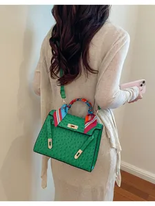 Detalle del elegante bolso Kelly verde con textura de avestruz y un pañuelo de seda.