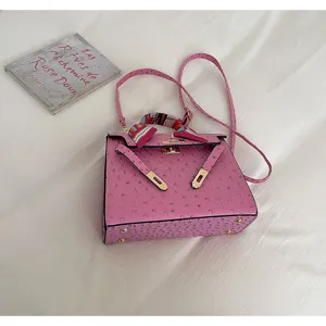 Pink ostrich pattern leather Kelly bag with golden hardware and chic scarf handle.