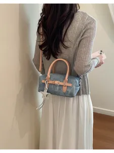 Vintage style denim texture small shoulder pillow bag with buckle and star pendant detail.