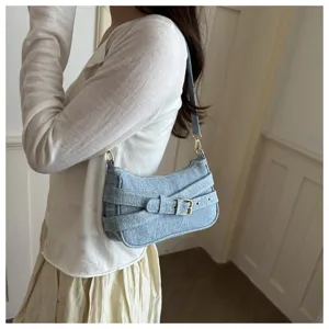 Close-up detail van de retro denim okseltas met decoratieve modieuze gespriemen.