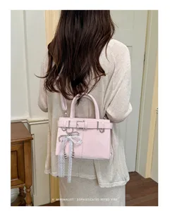 Modische rosa Schultertasche für Damen, schicker Retro-Viersektor mit Schleifenanhänger.