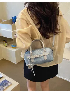 Vintage denim shoulder bag for women, trendy chic crossbody handbag with star pendant detail.