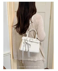 Elegante weiße Schultertasche für Damen, retro minimalistische Handtasche mit Spitze Anhänger.