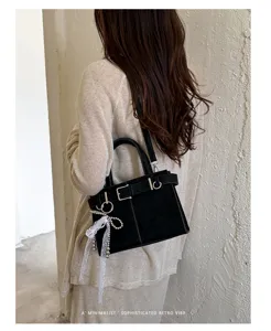 Detail des retro schwarzen Damen-Unterarm-Bags mit schicker Schnalle und Perlen-Anhänger.