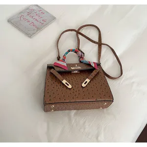 Trendy brown ostrich texture Kelly bag for women with elegant scarf and shoulder strap.