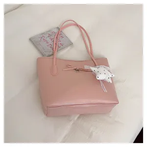Pink leather shoulder bag detail, sweet bow and star pendant, elegant women handbag close up