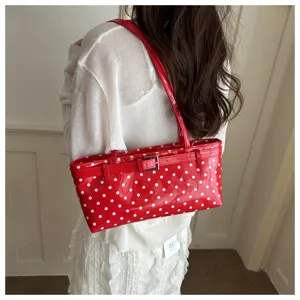 Stylish red polka dot patent leather shoulder bag for women, chic buckle design and chic look.