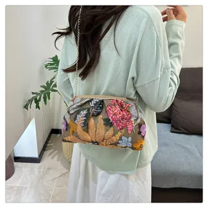 Borsa a tracolla con catena e paillettes ricamate, dettaglio elegante pochette da sera.