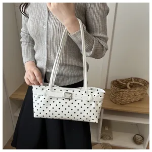 Chic polka dot handbag for women, stylish shoulder bag with belt accent and sleek design.