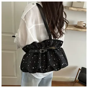 Close-up view of the trendy black star-print underarm shoulder bag with buckle strap.