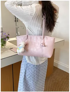 Pink PU leather shoulder tote bag detail with chic knotted handle and cute plush charm.