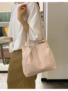 Bolso de hombro de lona rosa con lunares, tirantes trenzados y lazo dulce para uso diario.