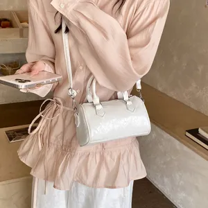 Chic white patent leather Boston handbag for women, stylish crossbody shoulder pillow bag.