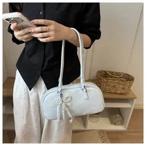 Bolso de hombro de charol con colgante de lazo de perlas, elegante bolso baguette detalle.