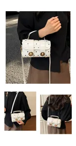 White polka dot shoulder bag for women, stylish commuting handbag with top handle and strap.