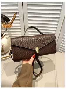 Nahaufnahme der braunen gewebten Ledertasche, exquisite Verarbeitung mit Metallverschluss und Henkel.