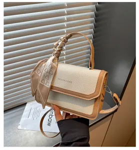 Gros plan détaillé du sac à épaule chic en similicuir beige avec poignée foulard.