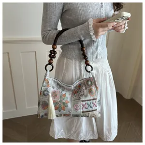 Vista dettagliata della borsa a spalla da donna alla moda con manico di perle e nappa.