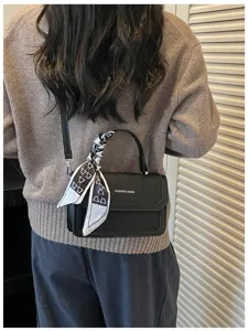 Sac bandoulière noir en cuir PU pour femme, élégant petit sac à rabat avec décor d'écharpe.