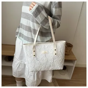 Detailed view of the white textured tote bag, showcasing casual daily commute style.