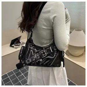 Detailansicht einer stylischen schwarzen Lackleder-Schultertasche mit Schnalle und Reißverschluss.