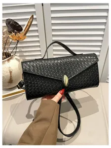 Detailansicht der schwarzen geflochtenen Handtasche mit edler Textur und goldenem Verschluss.
