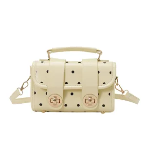 Beige polka dot women's shoulder bag with chic top handle and metal turn-lock closure.