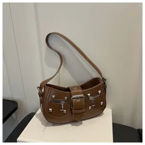 Borsa a tracolla in ecopelle marrone con borchie metalliche, doppie tasche e fibbia chic.
