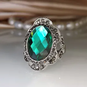 Detailweergave van de vintage groene edelsteenring met fijne metaalsnijwerk en kristalfacetten.