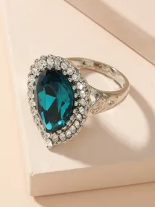 Detaillierte Nahaufnahme des Vintage-Blaukristallrings mit einer funkelnden Kristallfassung.