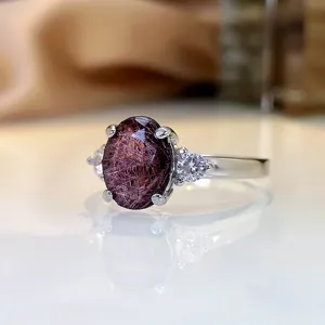 Detaillierte Nahaufnahme eines Vintage-Roter-Edelstein-Rings mit funkelnden Zirkoniasteinen.