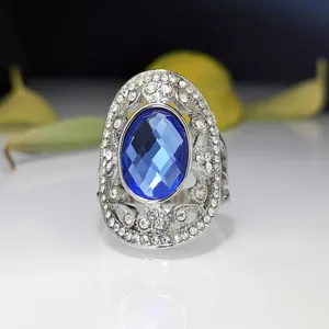 Close-up van vintage blauwe kristallen ring met sprankelende strass-steentjes in zilver design.