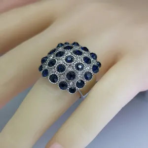 Gedetailleerd overzicht van een vintage vierkante cocktailring met blauwe en heldere stenen.