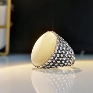 Detailed view of vintage chunky silver ring with large oval white stone for bold statement look.