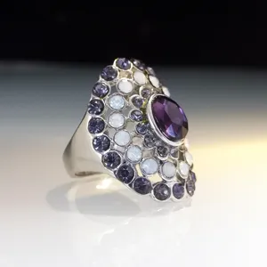 Detailed close-up of a statement crystal cocktail ring with purple and opal stones.
