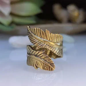 Close-up detail van een vintage goudkleurige open ring met een reliëf bladvorm.