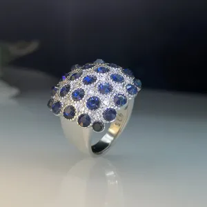 Close-up detail van de zilveren ring geplaveid met blauwe stenen en fijne kristallen.