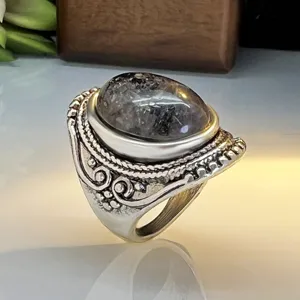 Vintage silver ring with ornate carved band and large oval dark natural stone statement jewelry.