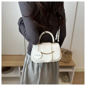 Stijlvolle witte schoudertas met metalen accent en modern zadeldesign voor dagelijks gebruik.