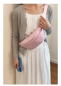 Detailed view of a trendy pink polka dot chest bag worn casually by a model in daily life.