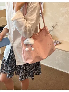 Pink canvas shoulder tote bag detail view showcasing cute smiling cloud charm and shiny stars.